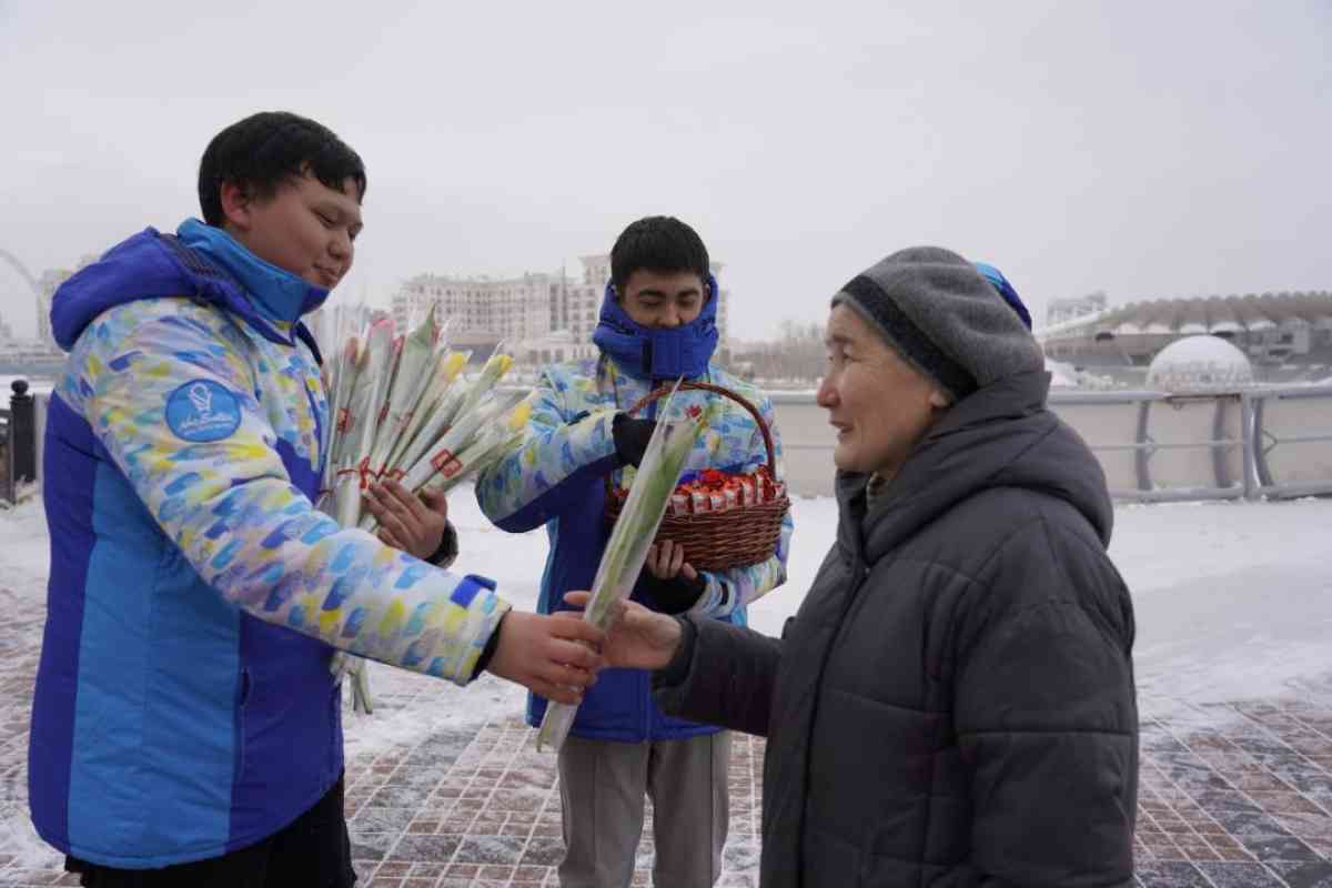 Цветы и шоколадки дарят женщинам на улицах Астаны